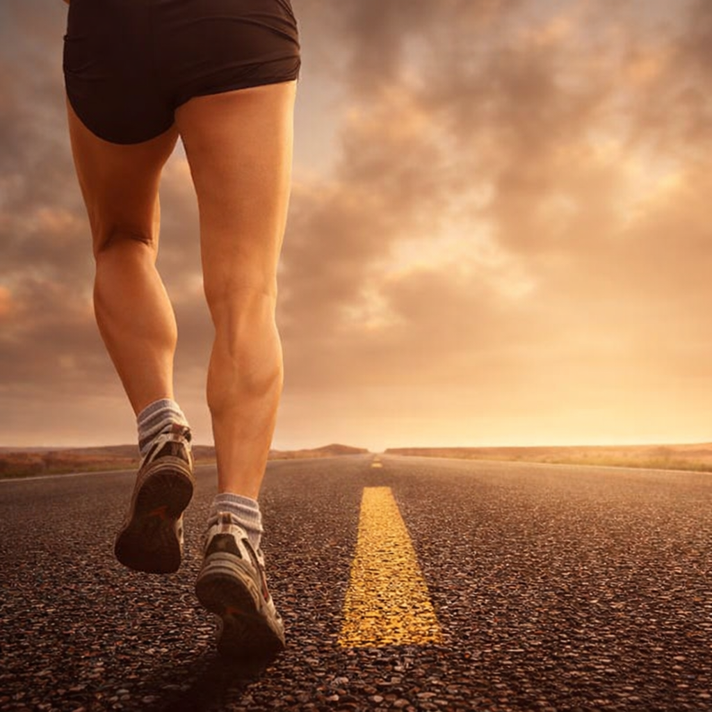 सड़क पर दौड़ते हुए रनिंग जूतों का क्लोज-अप शॉट