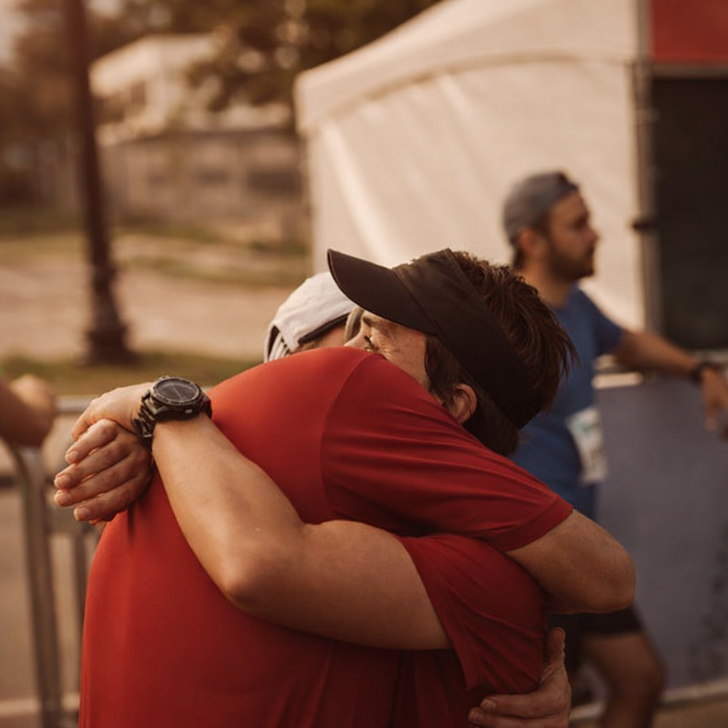 Two runners embrace warmly after