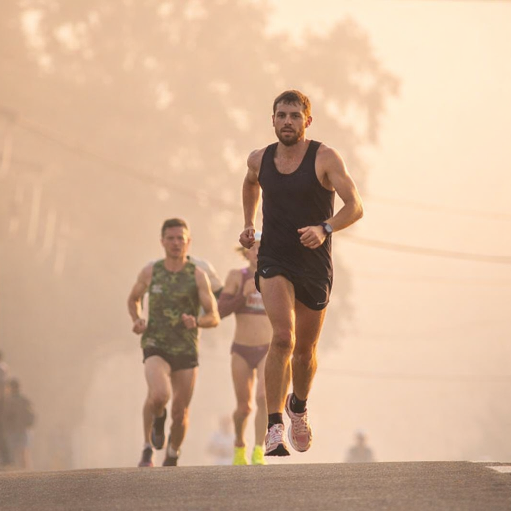 सुबह के समय मैराथन दौड़ते हुए हजारों धावकों का दृश्य